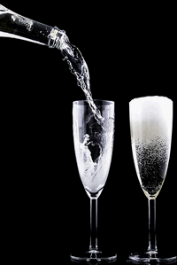 Bottle of champagne pouring into a glass