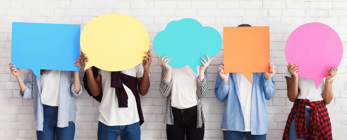 A group of young people all holding a speech bubble each.